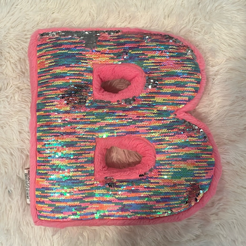It’s a B, sparkly sequence, pink pillow